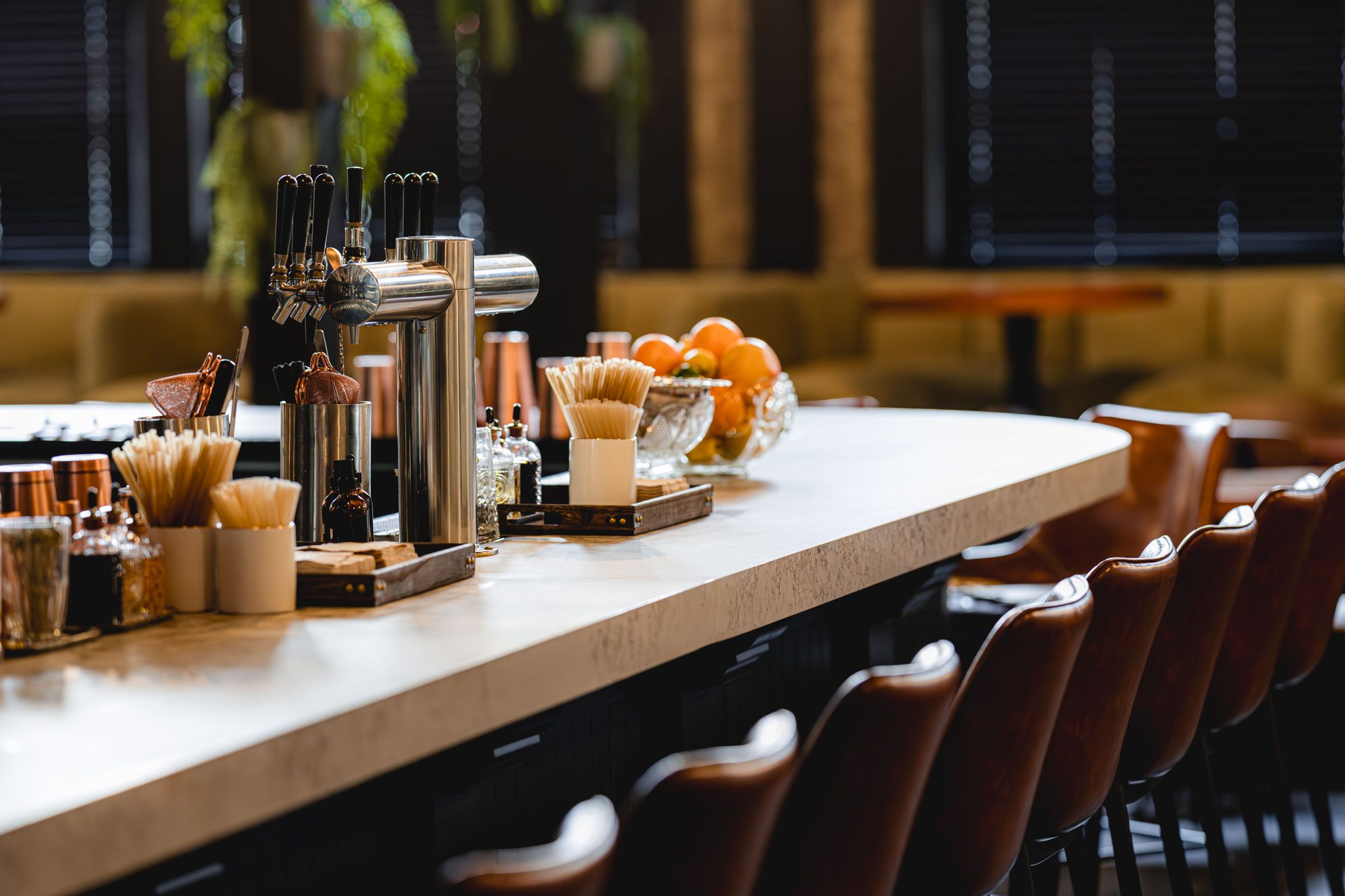 Detail of the Carmel bar counter with leather stools and brass fittings