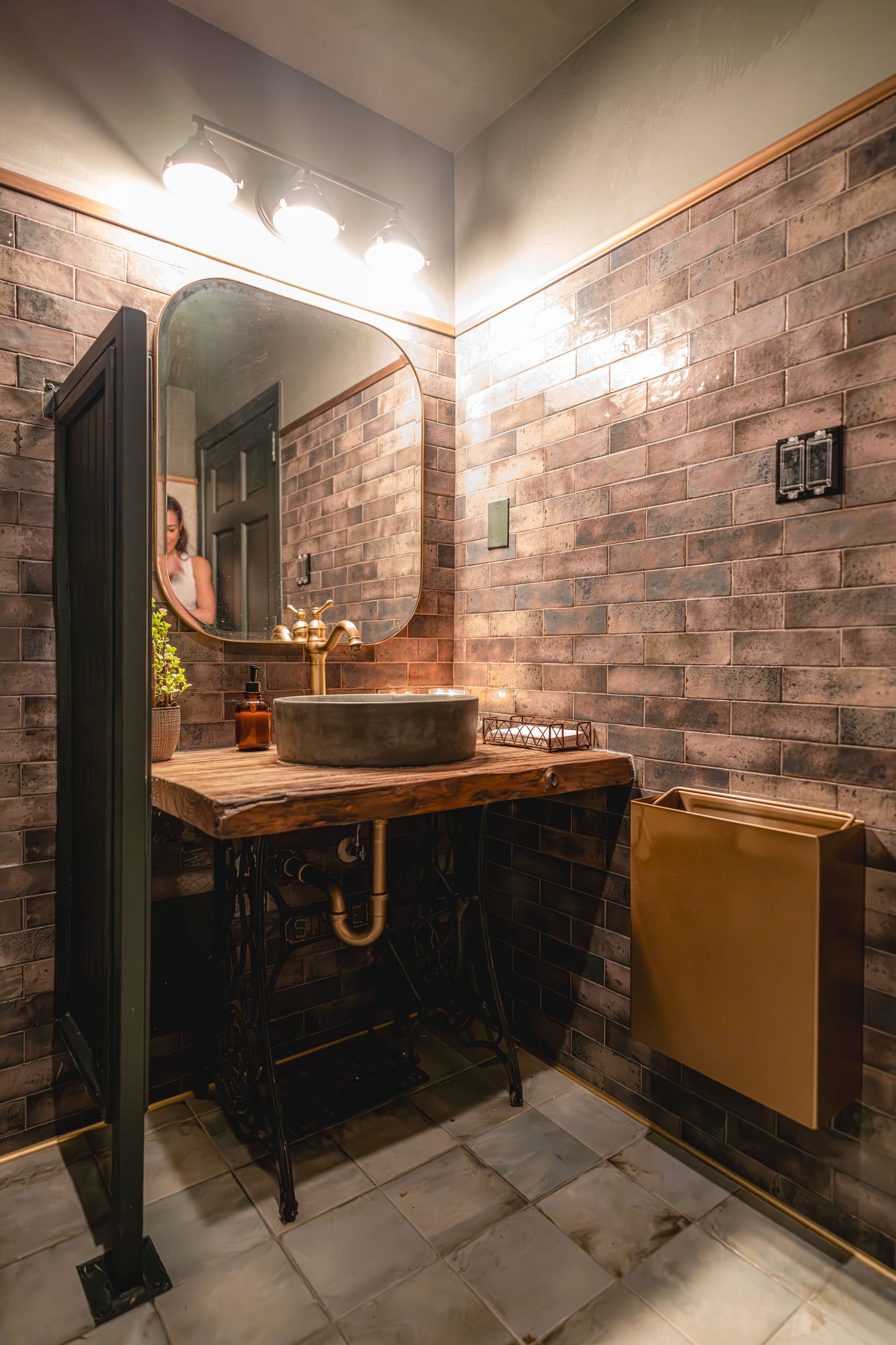 Carmel restroom vanity with stone basin, timber counter and arched mirror