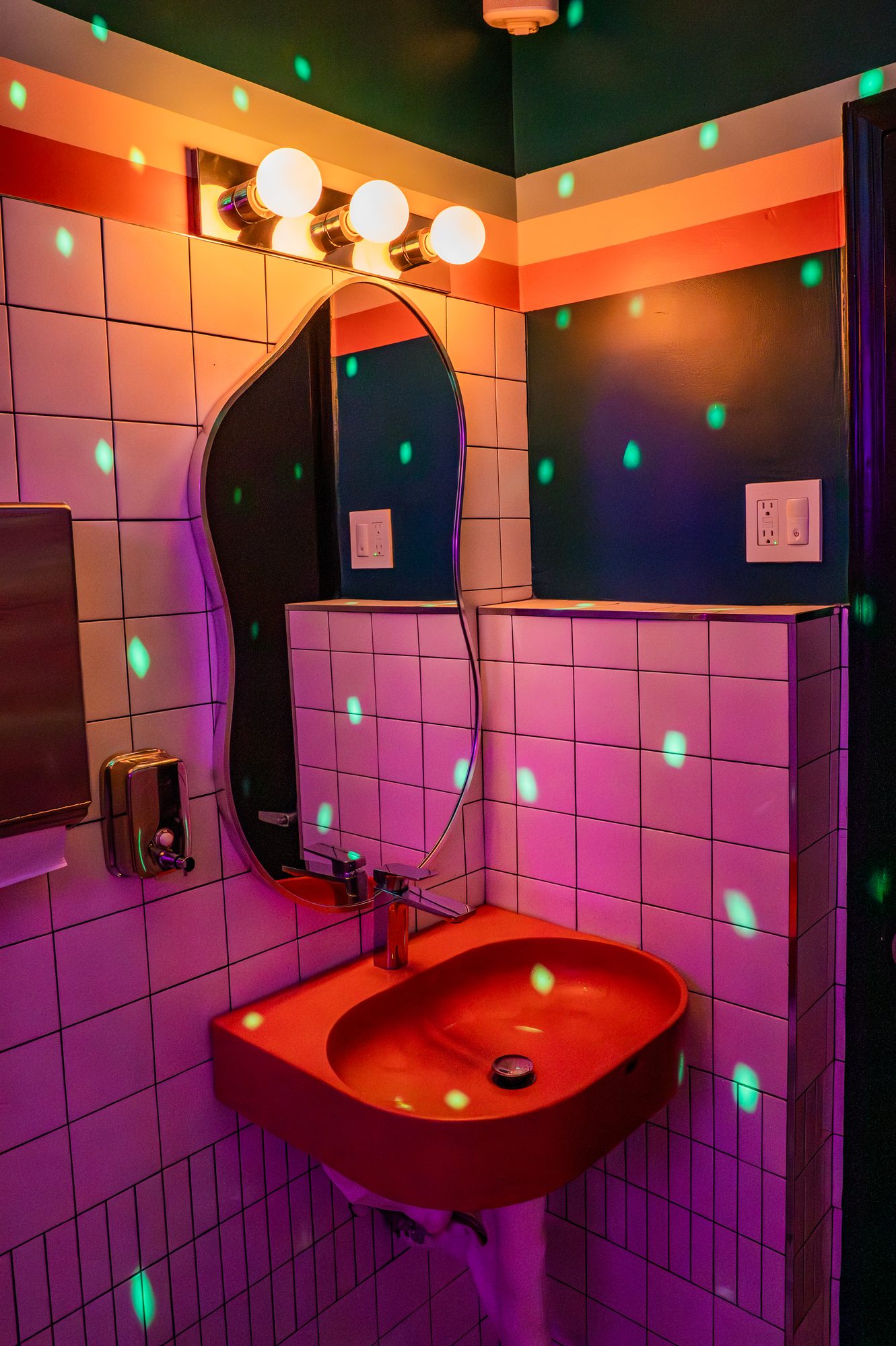 Corridor 18 restroom in magenta tile with mirrored disco lighting