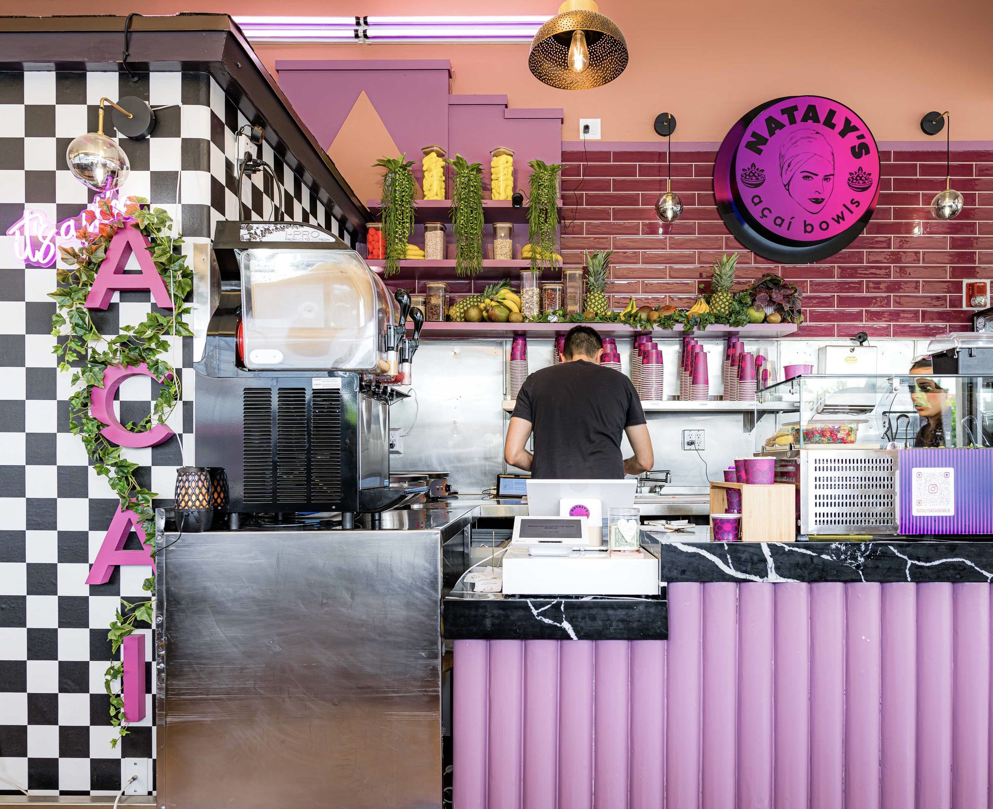 Open kitchen and lilac service counter at Nataly's Acai with checkerboard tile